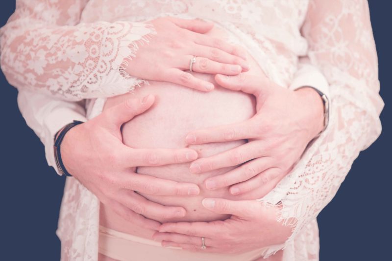 mains posées sur le ventre d'une femme enceinte